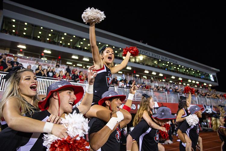 Cheerleaders cheer on sidelines at football game